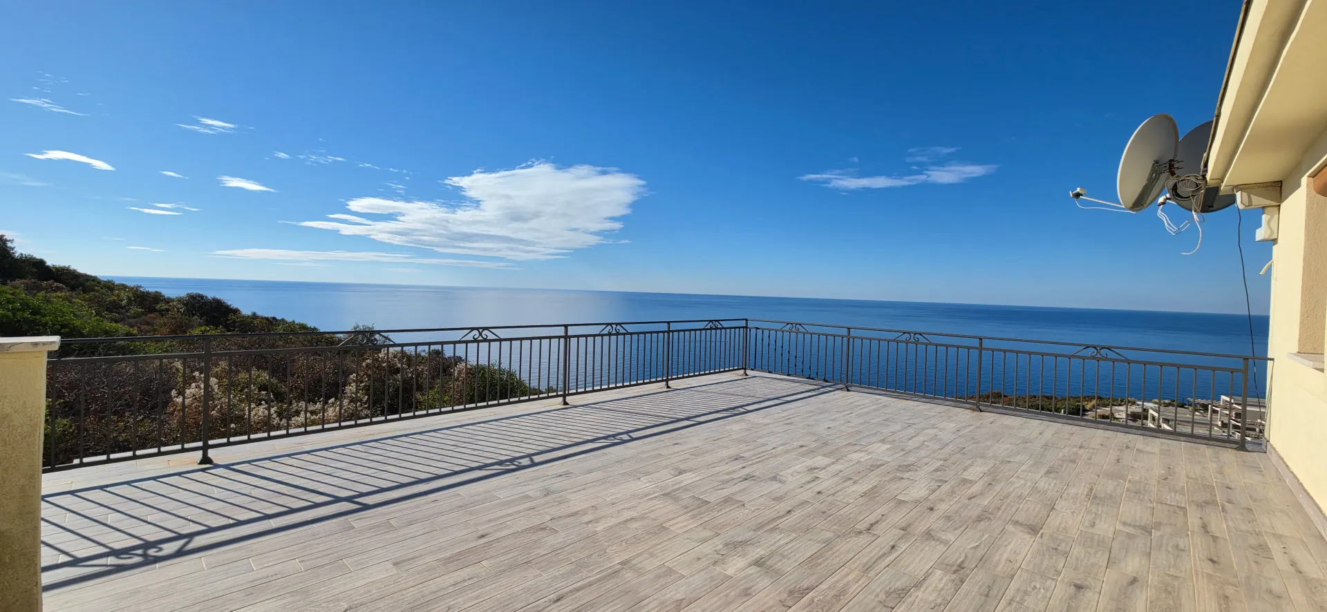 Large terrace with a sea view and metal railing.
