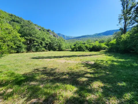 Pogled na zelenu livadu i okolne planine. - image 8