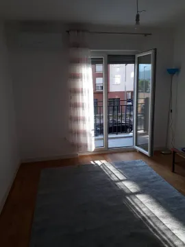 Living room with a rug and balcony doors leading to the terrace. - image 4
