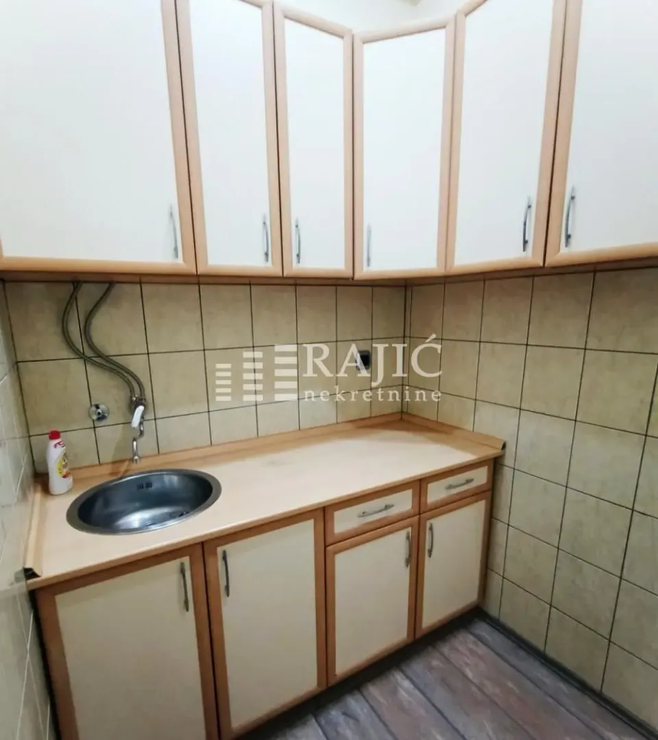 Small kitchen with a sink and wooden cabinets.