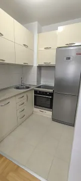Functional kitchen with beige cabinets and a refrigerator. - image 25