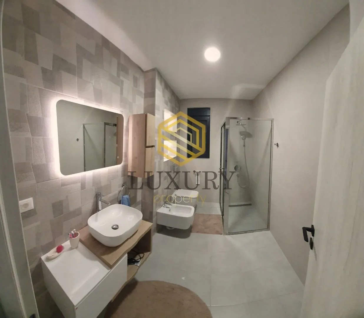 Modern bathroom with a sink, shower cabin, and sanitary fixtures.
