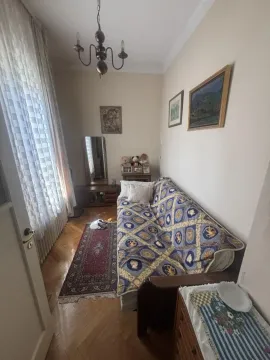 Small living room with a sofa, rug, and window with curtains. - image 9