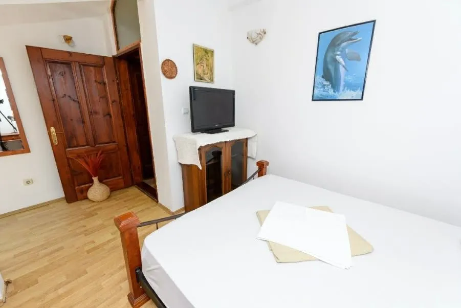Smaller bedroom with a double bed, wooden cabinet, and a TV.