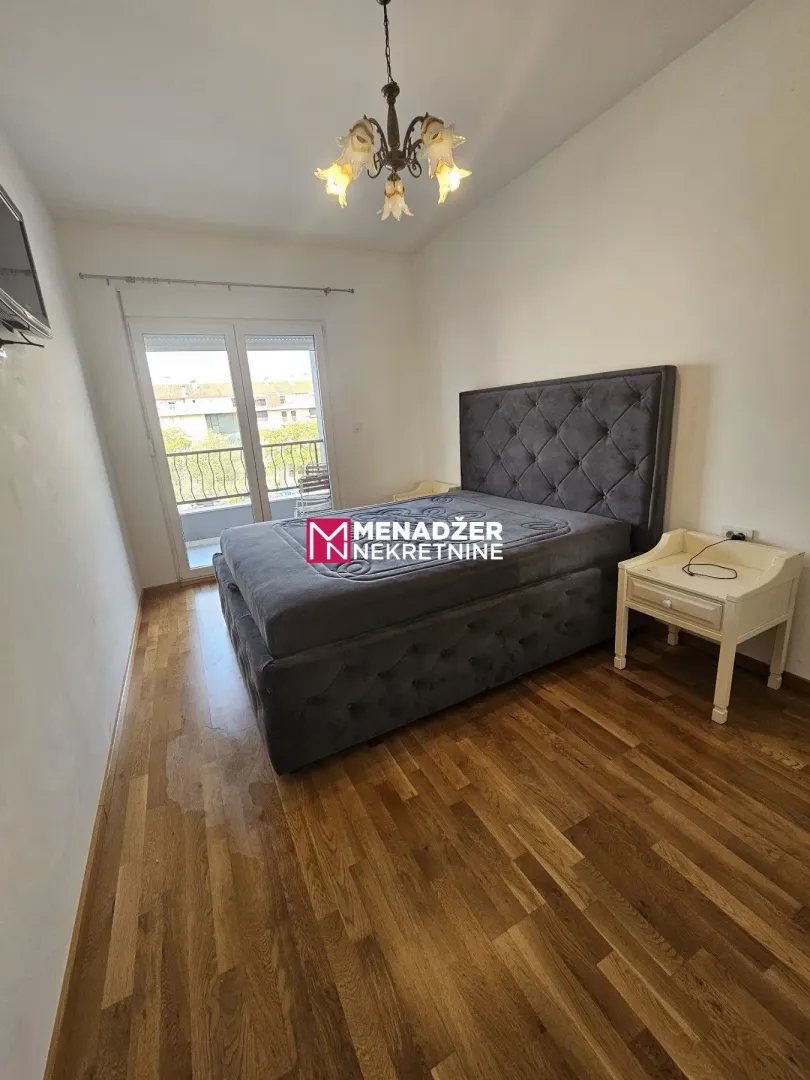 Bedroom with a double bed, nightstand, and balcony access.