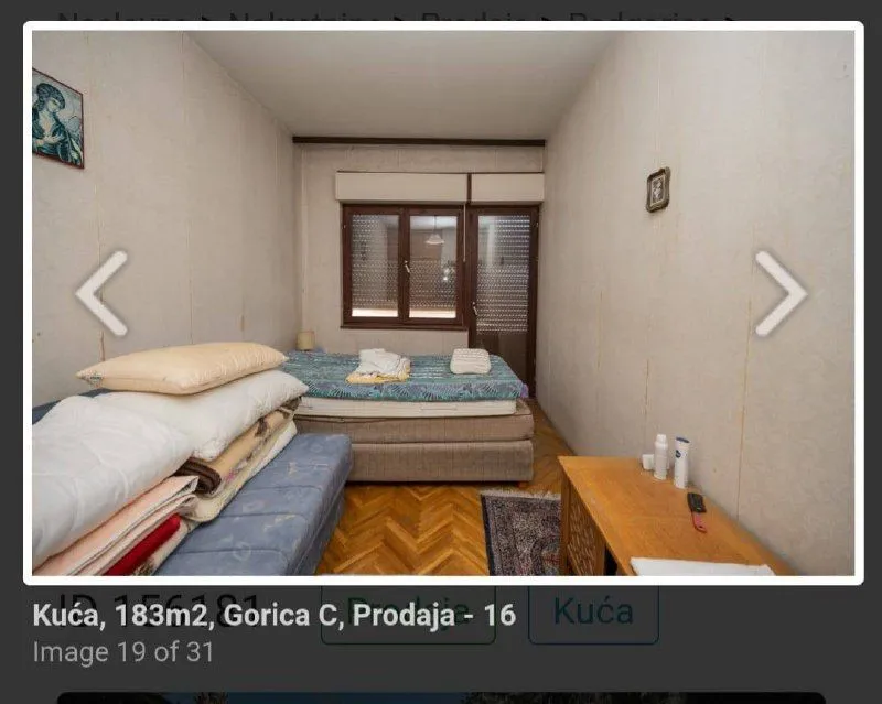 Manja spavaća soba sa krevetom i drvenim podom.