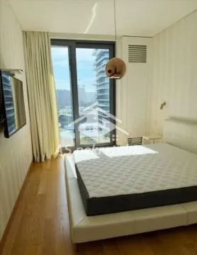 Spavaća soba sa bračnim krevetom, TV-om i velikim balkonskim vratima. - image 11