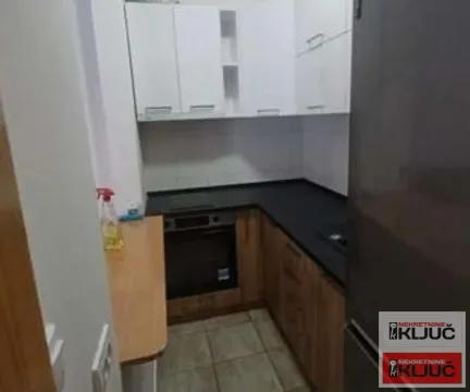 Manja kuhinja sa belim visećim elementima i tamnom radnom površinom. - image 3