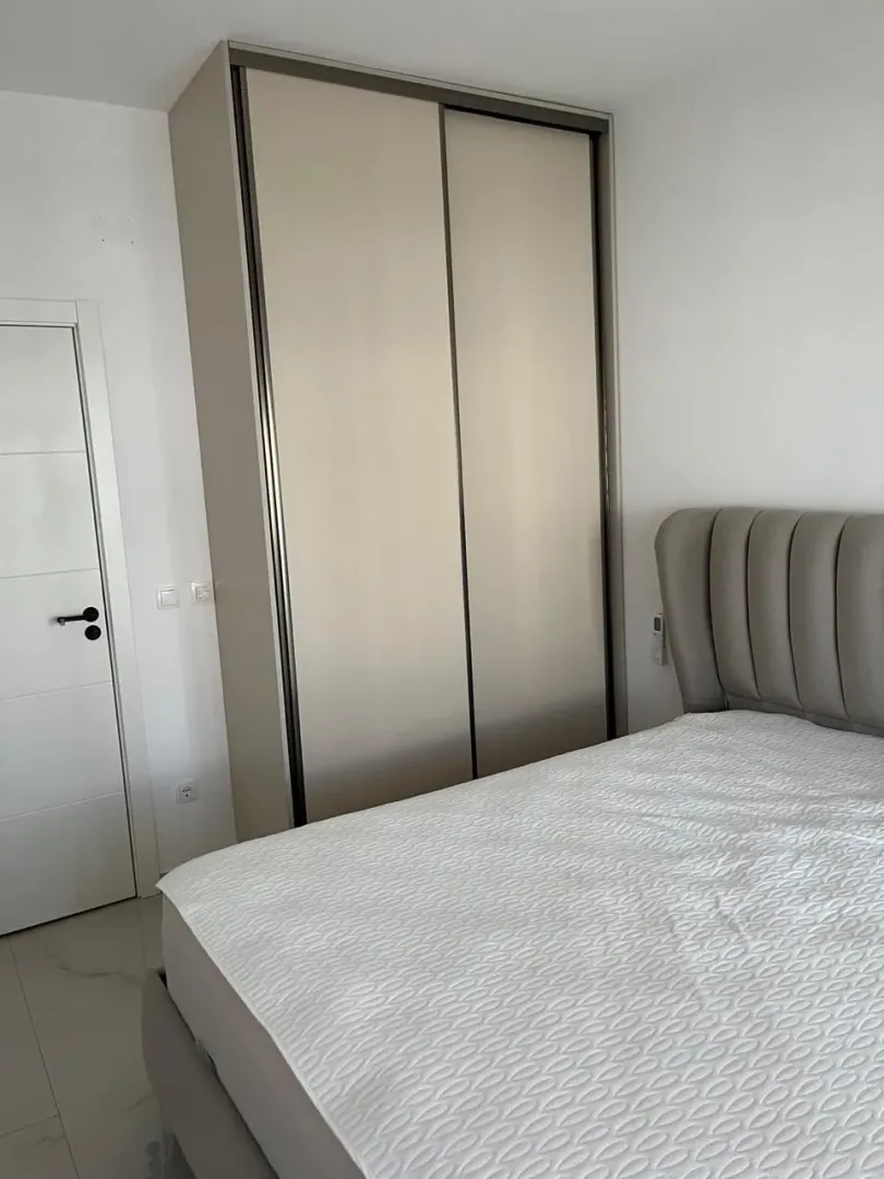 Spavaća soba sa bračnim krevetom i ugradnim ormarom.