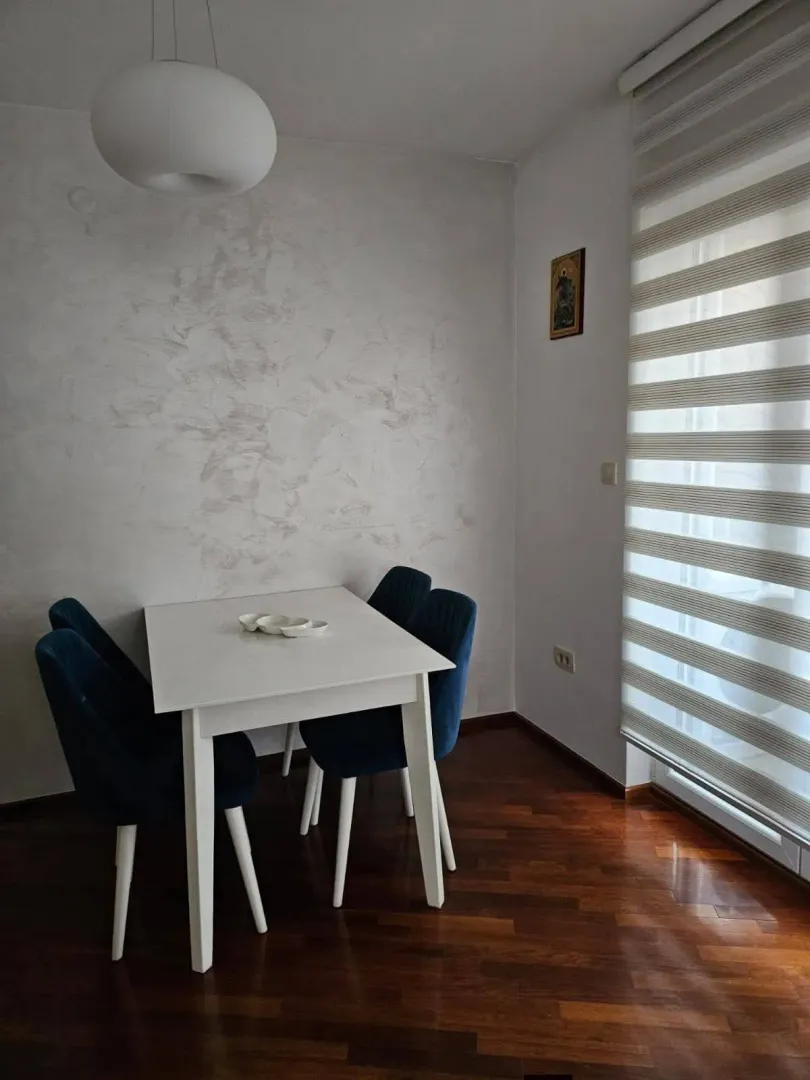 Trpezarijski sto sa plavim stolicama blizu prozora.