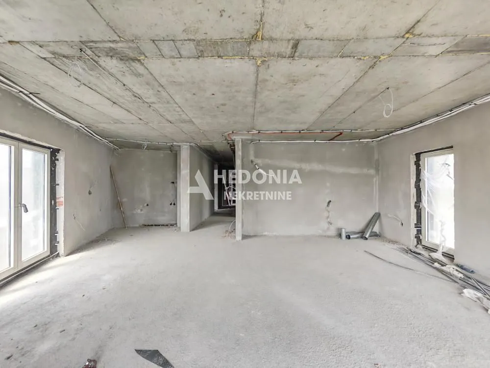 Pogled na prazan prostor u izgradnji sa betonskim podovima i zidovima.