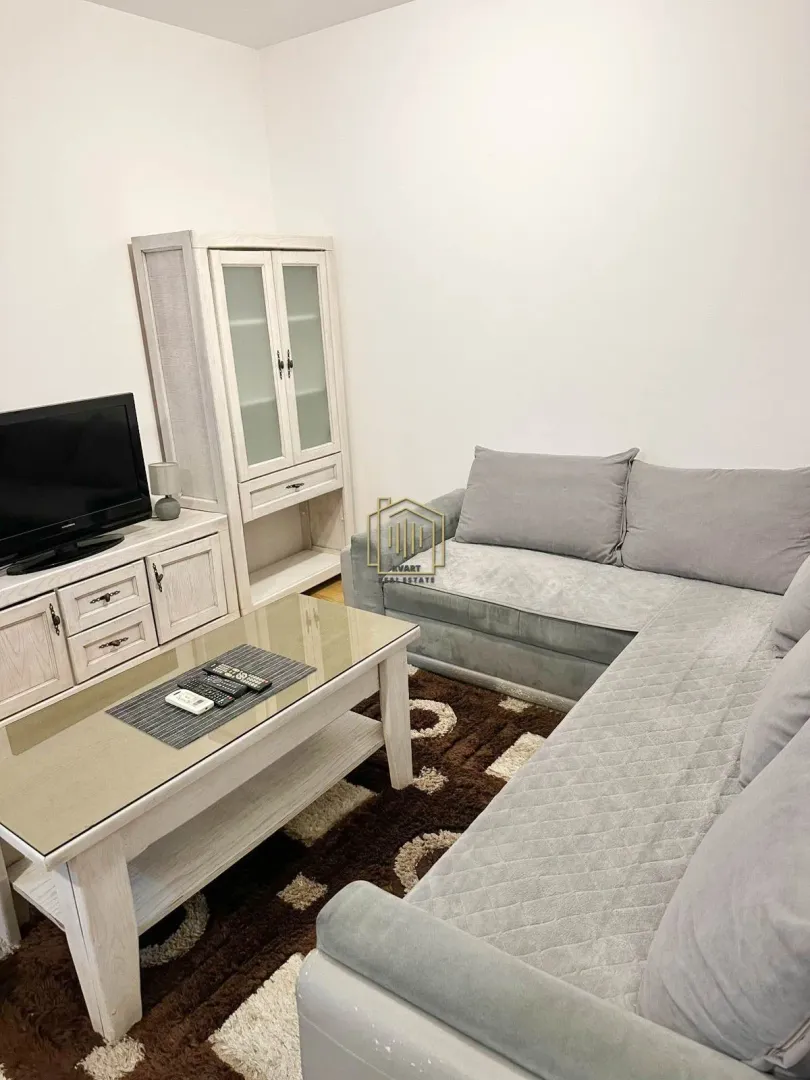 Living room with a sectional sofa, TV cabinet, and coffee table.