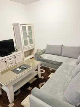 Living room with a sectional sofa, TV cabinet, and coffee table. - image 4