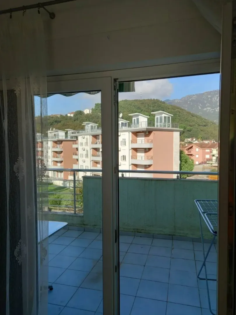 Pogled sa terase na okolne zgrade i brda.