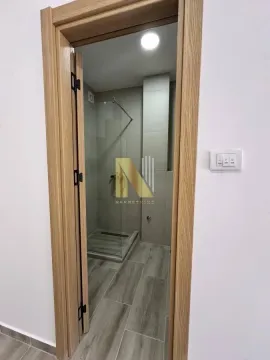 Pogled kroz drveni štok vrata na moderno uređeno kupatilo sa tuš kabinom. - image 7