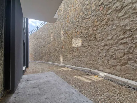 Pogled na spoljašnji dio objekta sa kamenim zidom i prilazom. - image 13