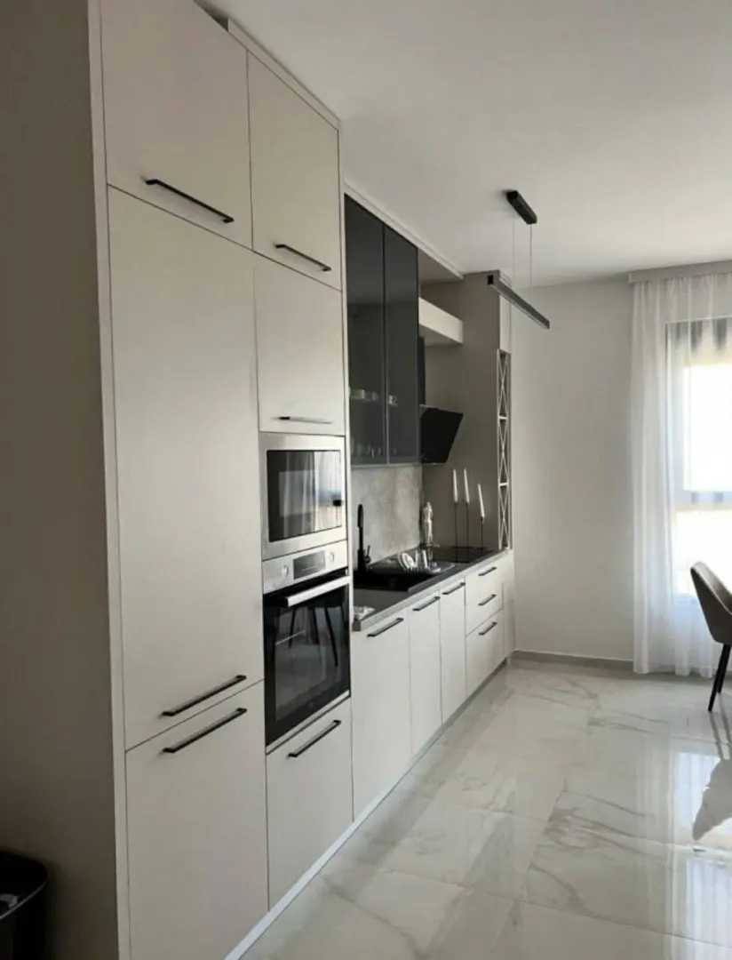 Modern kitchen with built-in appliances and light-colored cabinetry.