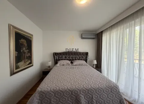Uređena spavaća soba sa bračnim krevetom, umjetničkom slikom i izlazom na terasu. - image 3
