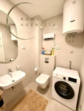 Manje kupatilo opremljeno sanitarijama, tuš kabinom i veš mašinom. - image 7