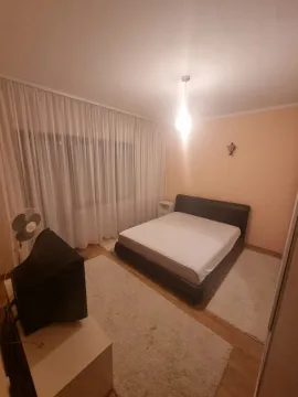 Namještena spavaća soba sa bračnim krevetom, televizorom i velikim prozorom sa zavjesama. - image 10