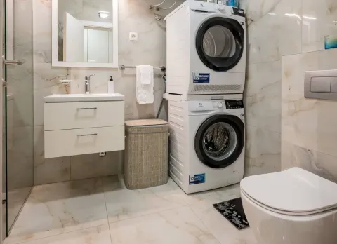 Kupatilo opremljeno umivaonikom, WC šoljom i mašinama za pranje i sušenje veša. - image 16
