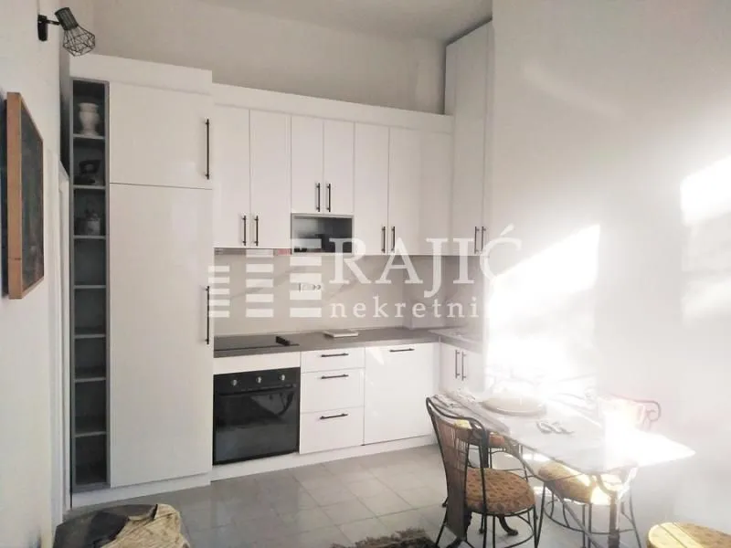 Modern white kitchen with a dining table.
