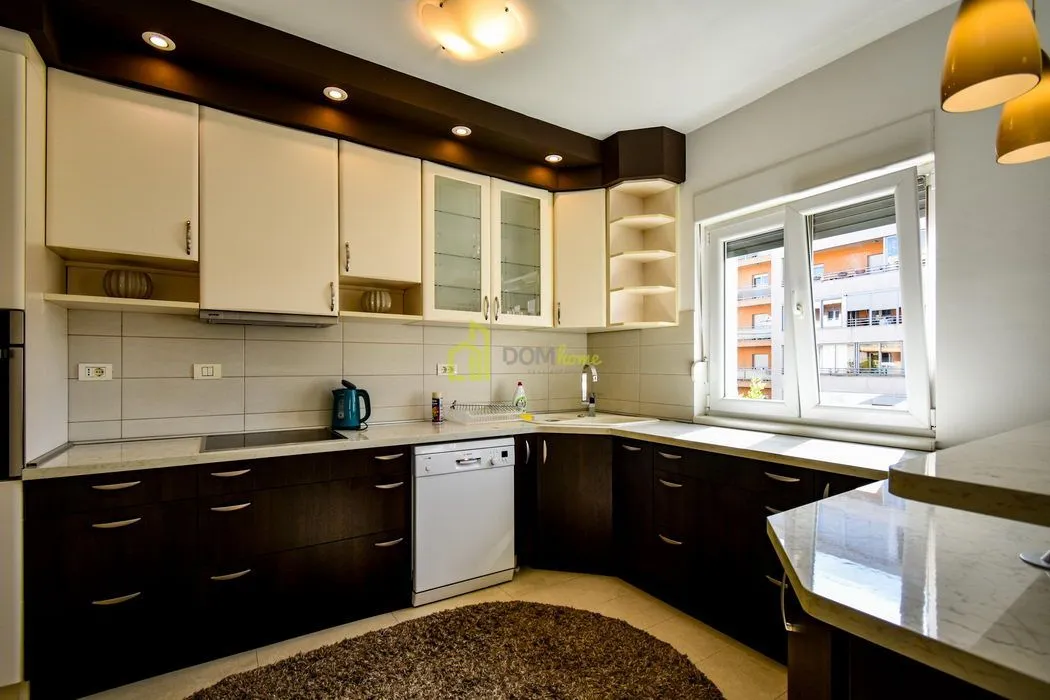 Kitchen with dark and light cabinetry and a window.