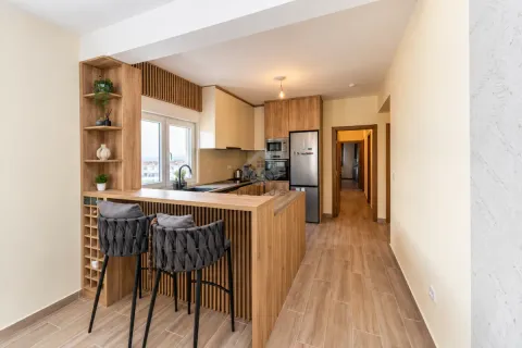 Modern kitchen with a breakfast bar, wooden elements and built-in appliances. - image 19