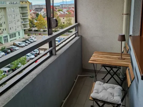 Manji namješteni balkon sa pogledom na ulicu i gradsko naselje. - image 4