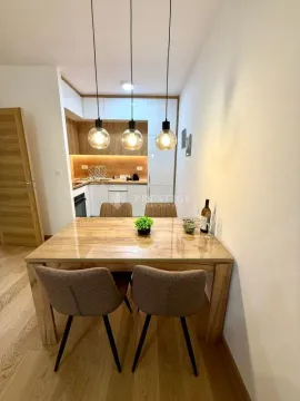 Dining area with a wooden table and chairs in a modern apartment. - image 5