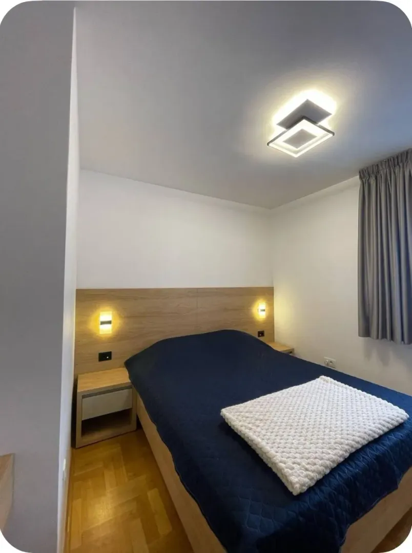 Bedroom with a double bed, wooden headboard and bedside tables.
