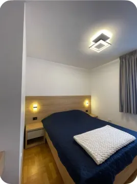 Bedroom with a double bed, wooden headboard and bedside tables. - image 3