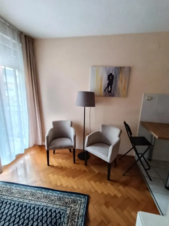 Small seating corner with two armchairs, a floor lamp, and an art painting on the wall.