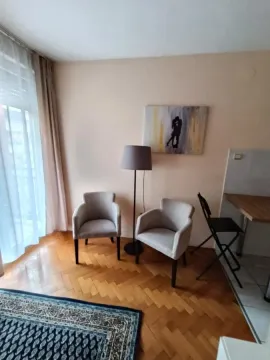 Small seating corner with two armchairs, a floor lamp, and an art painting on the wall. - image 8