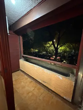 Covered balcony with a view of the parking lot and trees at night. - image 11
