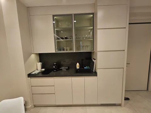 Modern kitchen with built-in cabinetry and illuminated glass display cabinets. - image 5