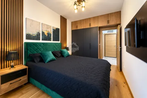 Modern bedroom with a double bed, built-in wardrobe, and a TV. - image 12