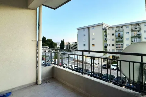 View from the balcony towards surrounding buildings and parking. - image 4