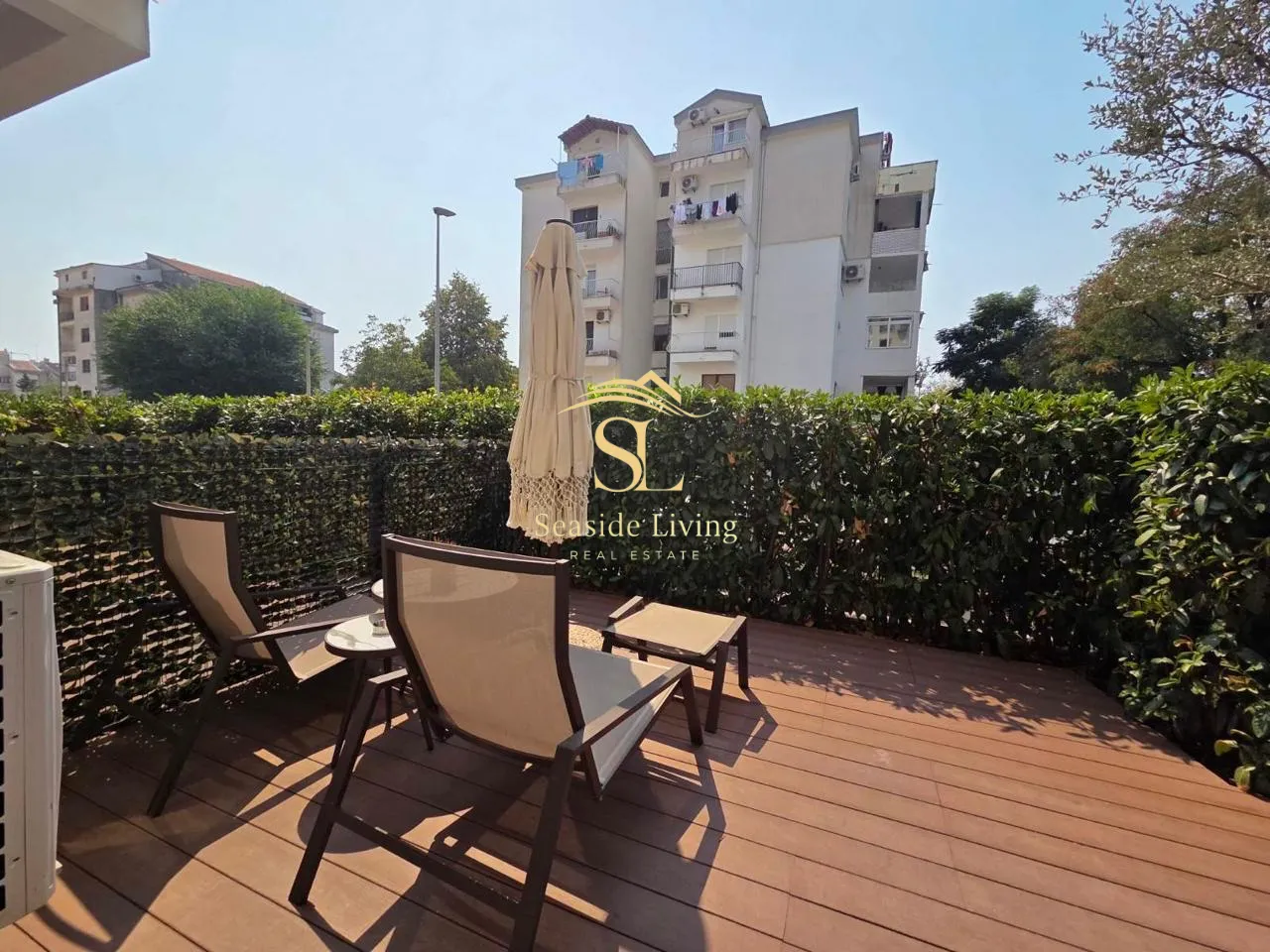 Wooden terrace with sun loungers and a view of the building.