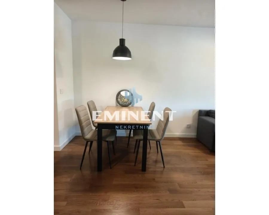 Dining area with a table, chairs, and a pendant lamp.