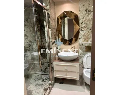 Luxuriously equipped bathroom with marble tiles, walk-in shower, and a unique mirror. - image 11