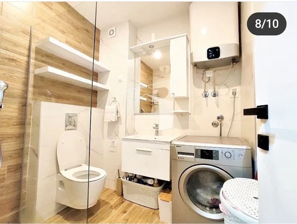 Bathroom equipped with sanitary fixtures, walk-in shower, washbasin, and washing machine.