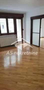 Empty room with hardwood flooring, a window, and a sliding door leading to another space. - image 2
