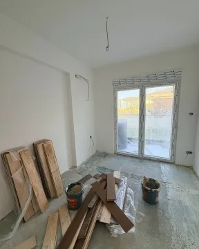 Empty room during renovation with hardwood flooring and installation materials. - image 3