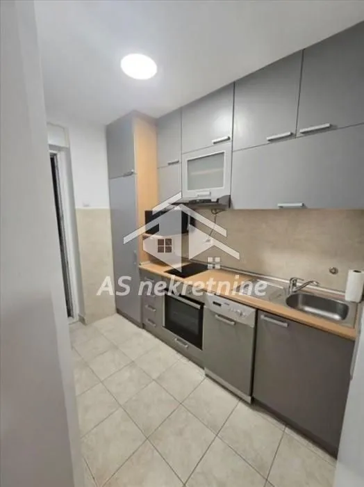 Small kitchen with grey cabinets and built-in appliances.