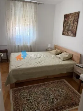 Spavaća soba sa bračnim krevetom, noćnim stočićima i prozorom sa zavesama. - image 5