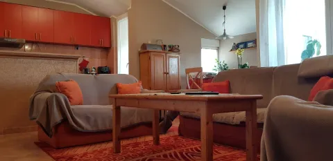 Svijetla dnevna soba sa udobnim kaučima i kuhinjskim elementima u pozadini. - image 2