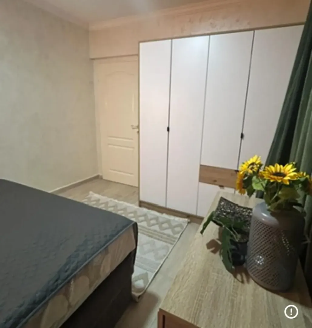 Namještena spavaća soba sa velikim garderoberom i bračnim krevetom.