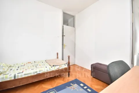 Manja spavaća soba sa krevetom, radnim stolom i parketom na podu. - image 9