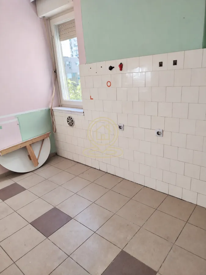 Manja kuhinja sa zidnim pločicama i prozorom.